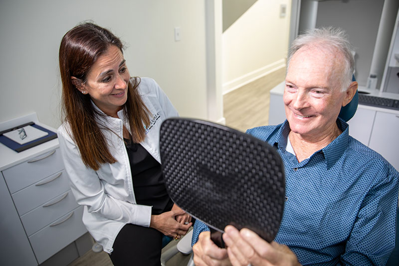 patient looking into mirror to see their new smile