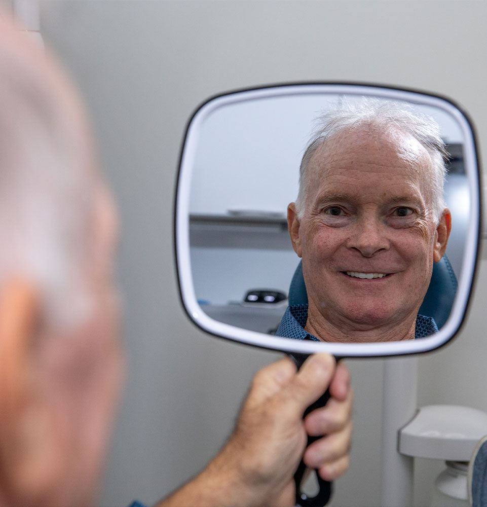 Patient looking into mirror smiling